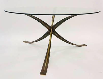 MANGEMATIN - TABLE DE SALLE À MANGER: Michel MANGEMATIN (1928) Importante table de salle à manger circulaire à piètement de forme hélice en bronze doré surmonté d'un plateau en verre. Années 1970 H : 71,