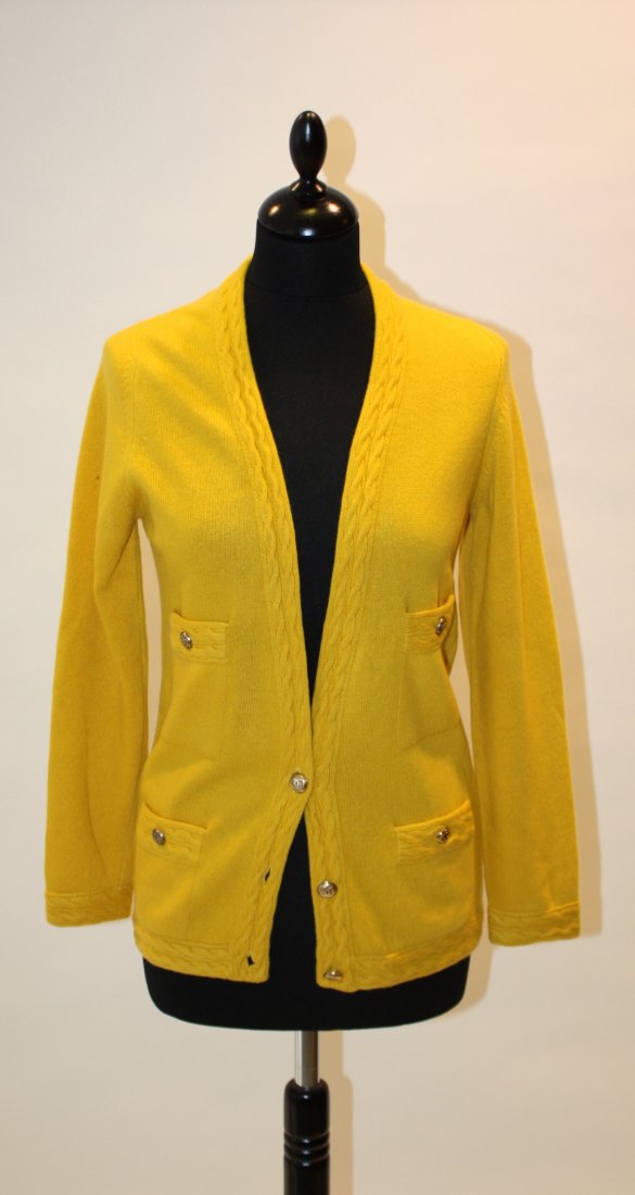 CHANEL - Gilet manches longues en cachemire jaune à: CHANEL - Gilet manches longues en cachemire jaune à bordures torsadées. Boutons en métal doré siglés. Taille 40. Très bon état.