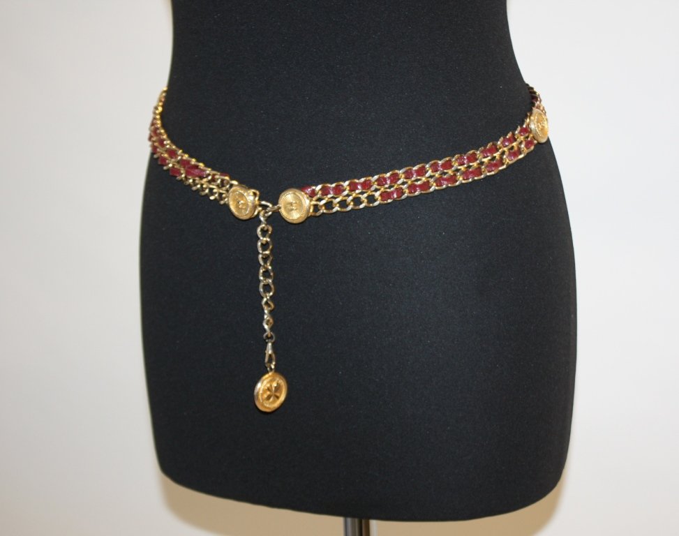 CHANEL Ceinture en chainettes de métal doré et ent: CHANEL Ceinture en chainettes de métal doré et entrelacs de cuir rouge, médaillons siglés. Petit manque, état d'usage