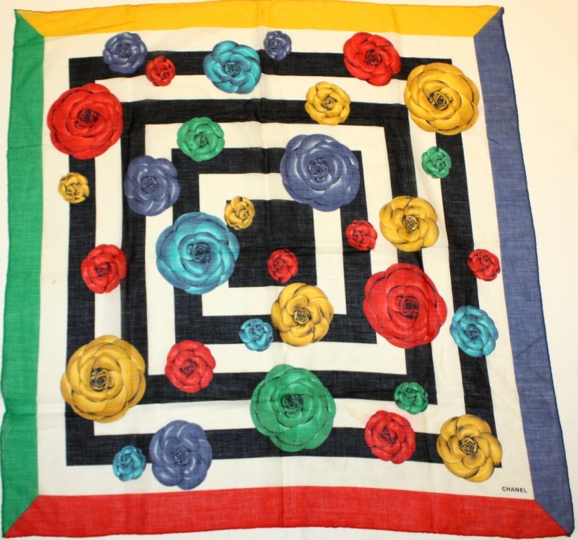 CHANEL - Carré en voile de coton orné de camélias : CHANEL - Carré en voile de coton orné de camélias multicolores sur fond de motifs géométriques. 90 x 90 cm