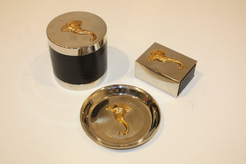 HERMES - Ensemble pour fumeur comprenant une boîte: HERMES - Ensemble pour fumeur comprenant une boîte à cigarettes, un cendrier et une boîte à allumettes en métal doré, chaque pièce ornée d'une corne d'abondance , très bon état