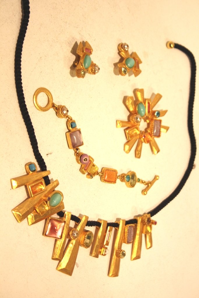 CHRISTIAN LACROIX- Collier composé d'éléments styl: CHRISTIAN LACROIX- Collier composé d'éléments stylisés mobiles sur un lien en coton noir, métal doré et pierreries. Bon état.