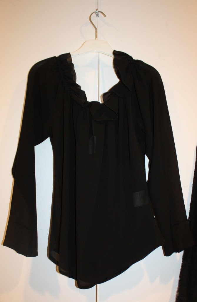 Yves Saint Laurent- Rive Gauche. Chemisier en soie: Yves Saint Laurent- Rive Gauche. Chemisier en soie noire agrémenté de volants au cou et aux manches. Taille 38. très bon état.