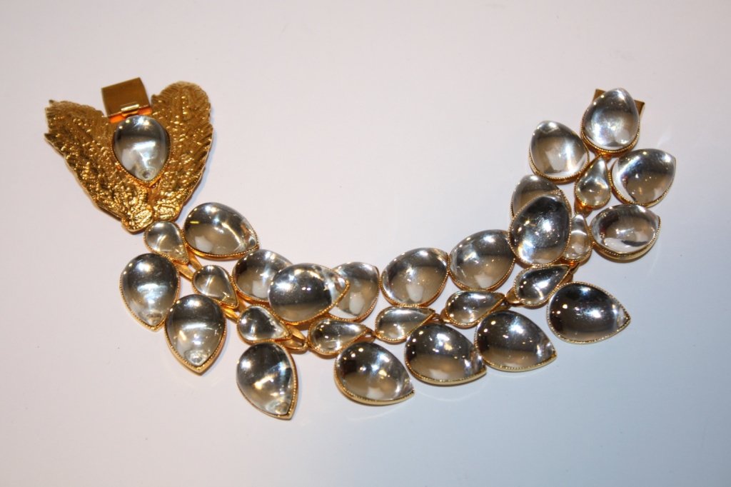 Yves Saint Laurent- Manchette articulée en métal d: Yves Saint Laurent- Manchette articulée en métal doré orné de strass blancs. Vers 1980. très bon état.