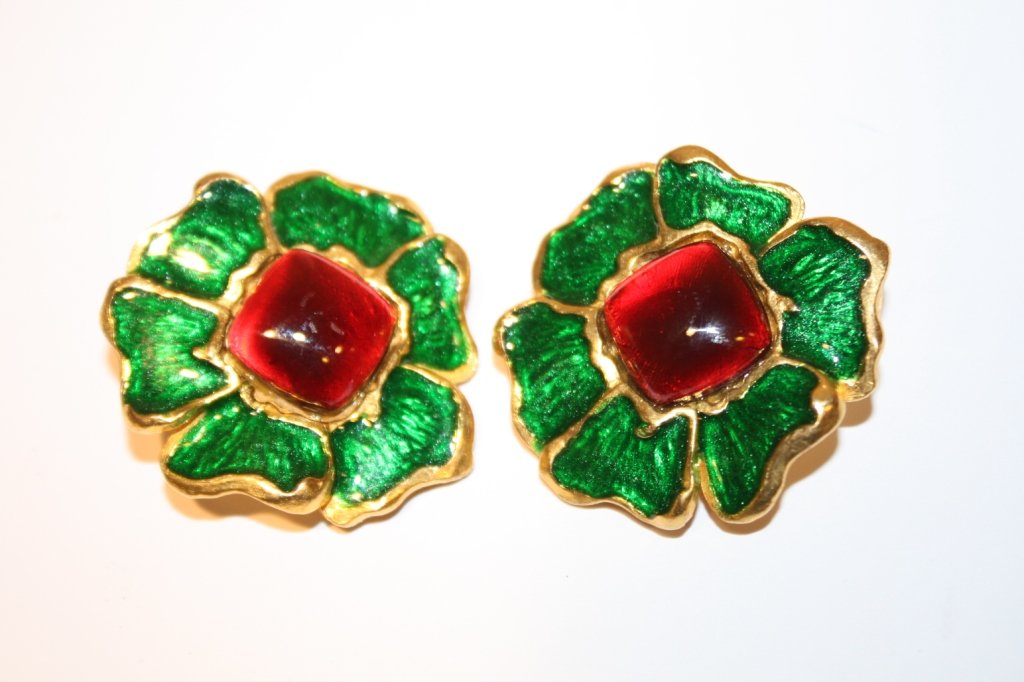 Yves Saint Laurent- paire de boucles d'oreilles fi: Yves Saint Laurent- paire de boucles d'oreilles figurant une fleur en métal doré et émaillage vert et rouge. Vers 1980. Très bon état.