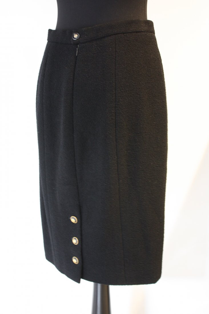 CHANEL- Jupe droite. Trois boutons siglés, noirs e: CHANEL- Jupe droite. Trois boutons siglés, noirs et dorés àl'arrière. Taille 44 (indiquée). Bon état.