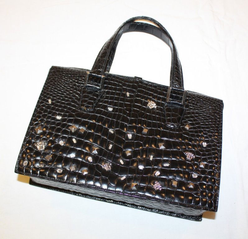 GIANNI VERSACE-Sac porté main en cuir façon crocodile n: GIANNI VERSACE-Sac porté main en cuir façon crocodile noir et incrustations de pierreries et de petits sigles et motifs géomètriques en métal, intérieur en cuir noir avec deux poches dont une zi