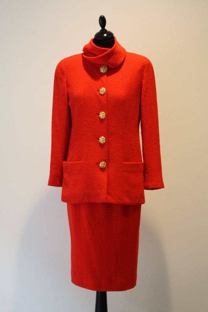 CHANEL boutique- Tailleur jupe en laine rouge orangée. : CHANEL boutique- Tailleur jupe en laine rouge orangée. Veste à col écharpe frangé, gros boutons en bas relief doré, doublure soie. Très bon état.