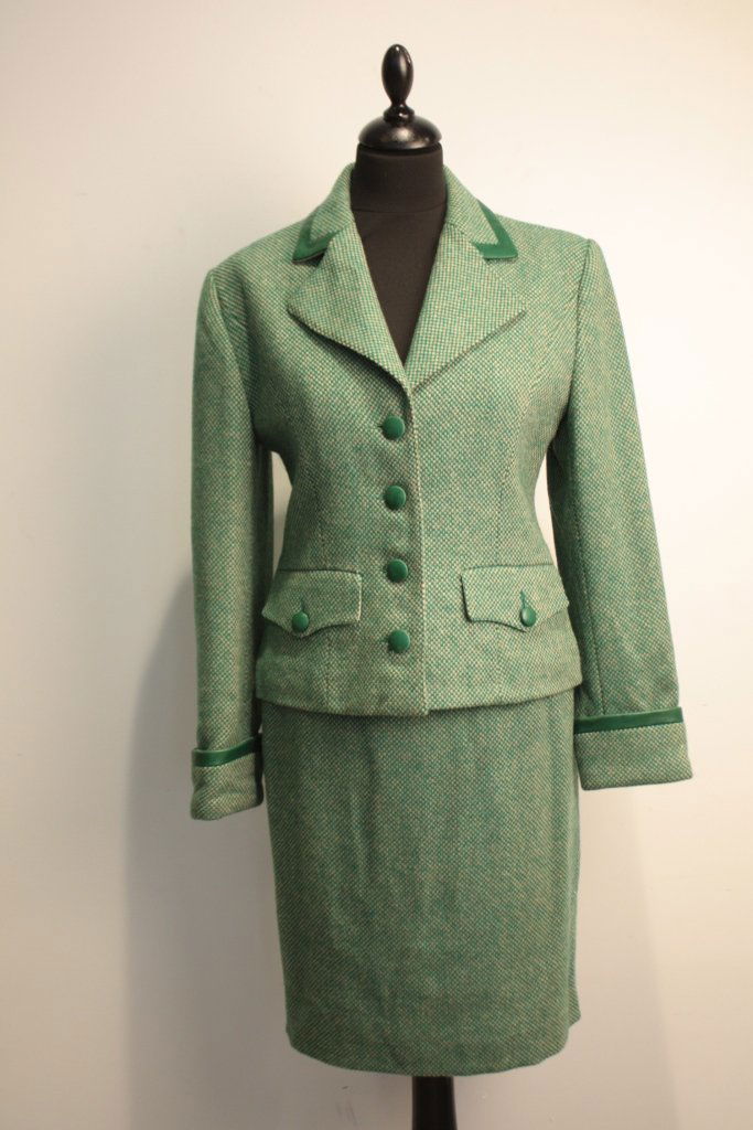 Guy Laroche - Tailleur en laine tweedée beige et vert, : Guy Laroche - Tailleur en laine tweedée beige et vert, boutons en cuir vert, veste en col orné de cuir vert, jupe droite - taille 36. Bon état.
