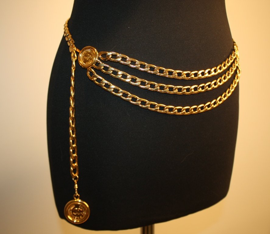 CHANEL - Ceinture en métal doré formée d'une chaînette : CHANEL - Ceinture en métal doré formée d'une chaînette ornée de trois médaillons siglés " rue Cambon". Bon état