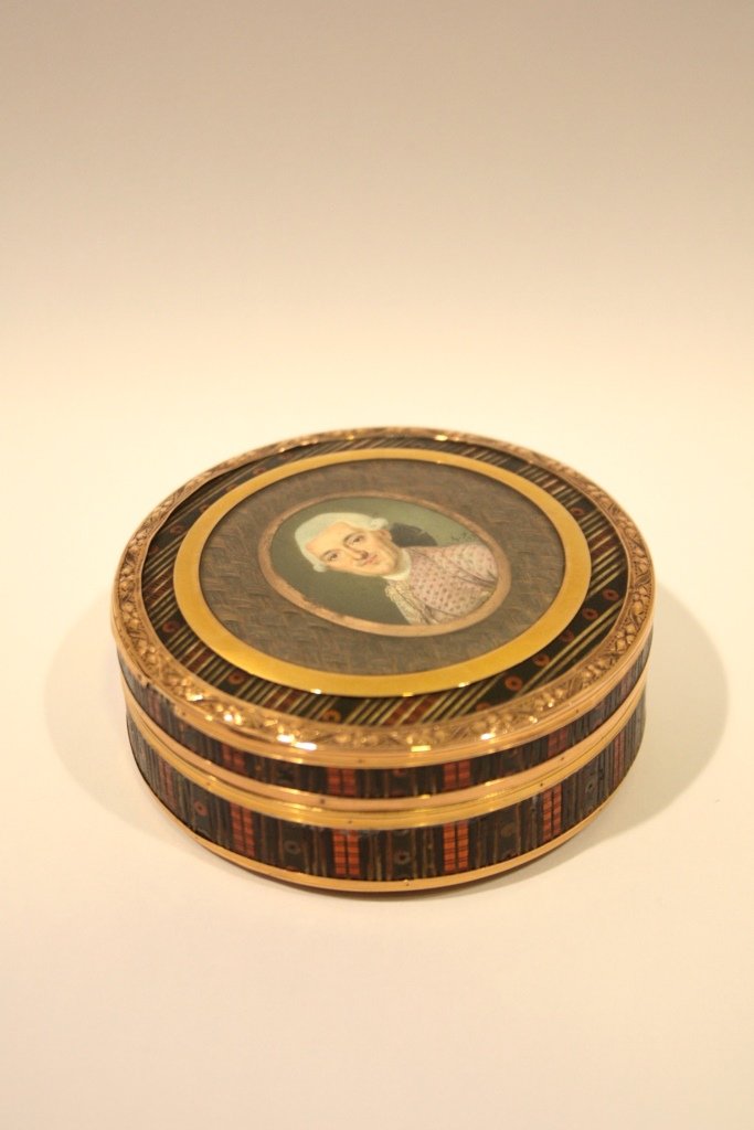 Boîte circulaire en écaille rouge ornée sur le: Boîte circulaire en écaille rouge ornée sur le couvercle et sur fond de cheveux tressés d'une miniature sur ivoire figurant un gentilhomme (portrait présumé du baron d'Escure ou d'un membre de s