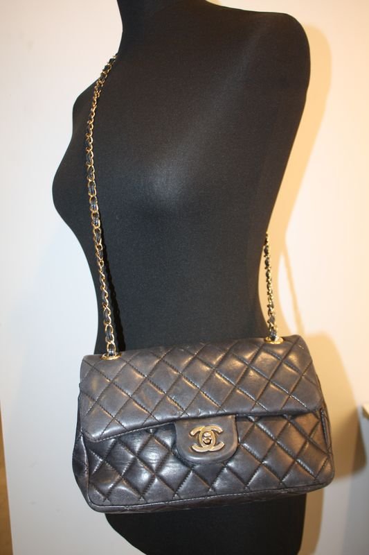 CHANEL Sac modèle 2.55 en cuir matelassé noir.: CHANEL Sac modèle 2.55 en cuir matelassé noir. Bandoulière en entrelacs de métal et cuir noir. Intèrieur en cuir bordeau. Etat d'usage.