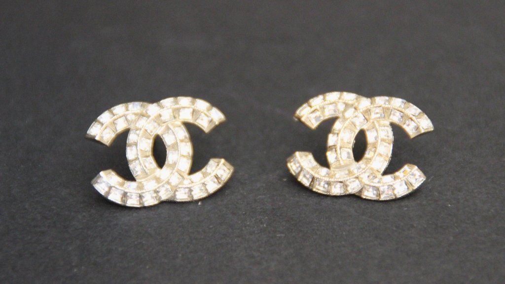 CHANEL Paire de boucle d'oreille en métal doré: CHANEL Paire de boucle d'oreille en métal doré figurant le sigle de la marque recouvert de strass Bon état