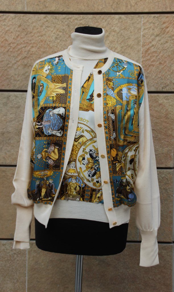 HERMES Twin-set en cachemire ivoire Et soie imprimée à: HERMES Twin-set en cachemire ivoire Et soie imprimée à décor De cartes de tarots Composé d'un pull manches Longues, col roulé et d'un Cardigan. Taille 36/38 environ Bon état