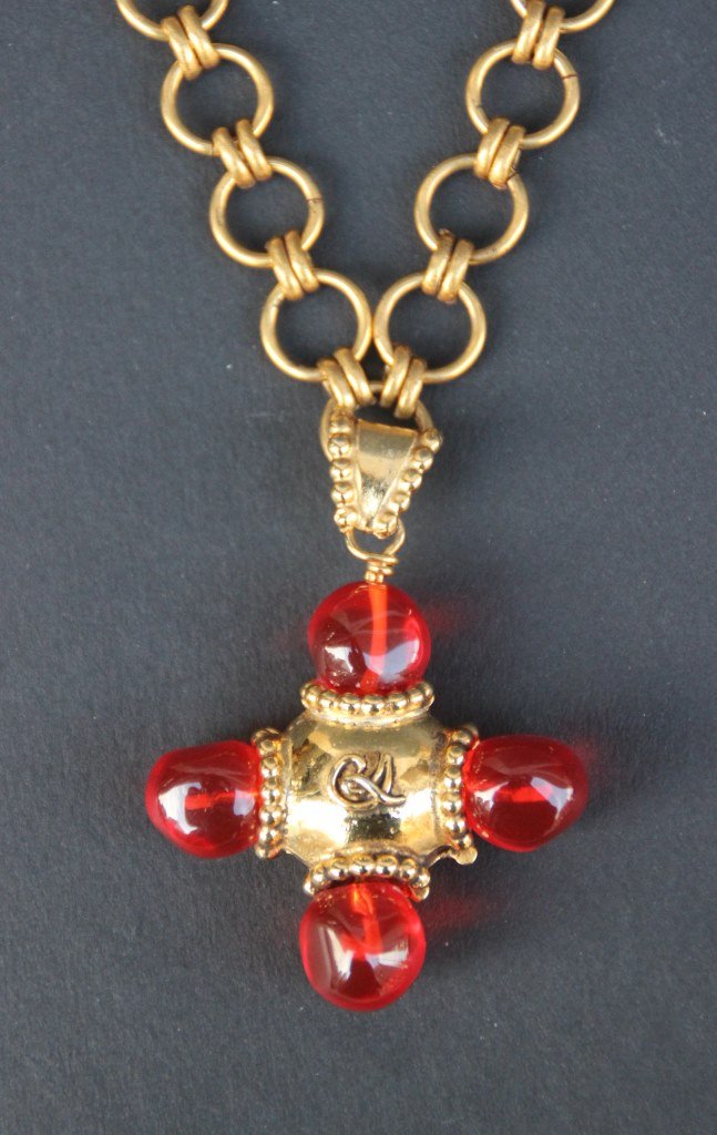 CHRISTIAN LACROIX Sautoir composé d'une croix en Pâte: CHRISTIAN LACROIX Sautoir composé d'une croix en Pâte de verre rouge et métal Doré et d'une chaine en métal Doré. Bon état