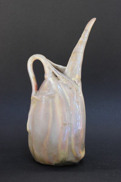 Jérôme MASSIER (1850-1926) Pichet en porcelaine de: Jérôme MASSIER (1850-1926) Pichet en porcelaine de forme coloquinte à lustre métallique rose H : 19 cm (restauration au bec)