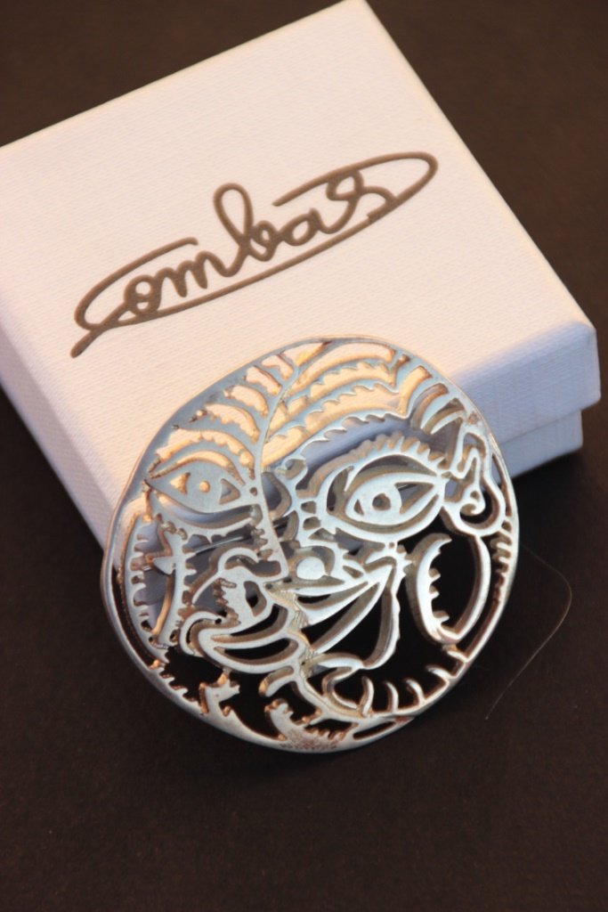 Robert COMBAS (1957) Visage Broche et pendentif en: Robert COMBAS (1957) Visage Broche et pendentif en métal argenté Signé au dos Edition pour le musée d'art moderne de Lyon lors de sa rétrospective 6 x 5,5 cm Dans son écrin d'origine