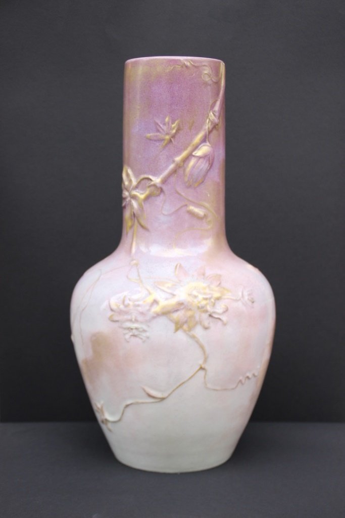 CLEMENT MASSIER (1844-1917) Grand vase balustre en: CLEMENT MASSIER (1844-1917) Grand vase balustre en faïence à décor en ronde bosse de rameaux de vignes et de feuillages sur fond rose et violine, rehaussé d’or. Quelques usures d’émail. Sign�