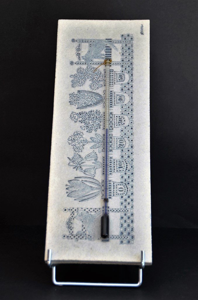 Roger CAPRON (1922-2006) Thermomètre en faïence: Roger CAPRON (1922-2006) Thermomètre en faïence émaillée de couleur bleue et blanche représentant des pots de fleurs et animaux. Signé en haut à droite. H : 40 cm, L : 15 cm.