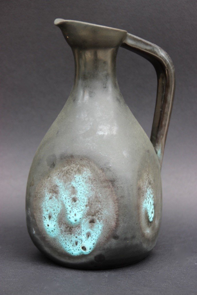 ACCOLAY Pichet en céramique émaillée noir rehaussé de: ACCOLAY Pichet en céramique émaillée noir rehaussé de pastilles bleu turquoise. Signé "Accolay" en dessous. H : 22 cm.