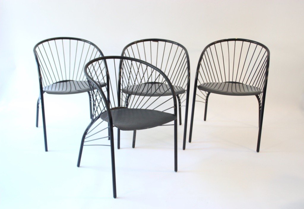 Travail italien - vers 1985 Suite de sept chaises en: Travail italien - vers 1985 Suite de sept chaises en tube de métal noir satiné, à assises arrondies et à décors de barrettes dans les dossiers reposant sur quatre pieds à réception en patins de