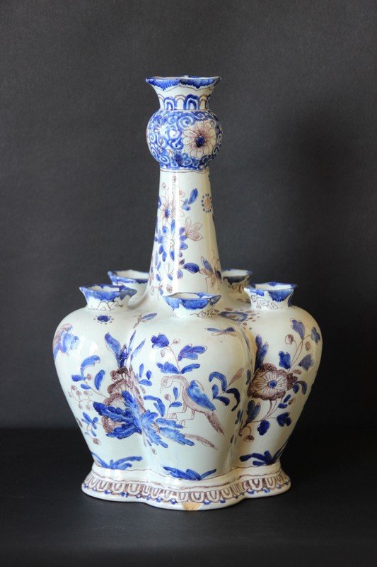 Tulipière en faïence émaillée à décors en bleu et brun: Tulipière en faïence émaillée à décors en bleu et brun de paysage animé, volatiles, et fleurs Marqué "N" à l'émail bleu dessous. H : 30 cm.
