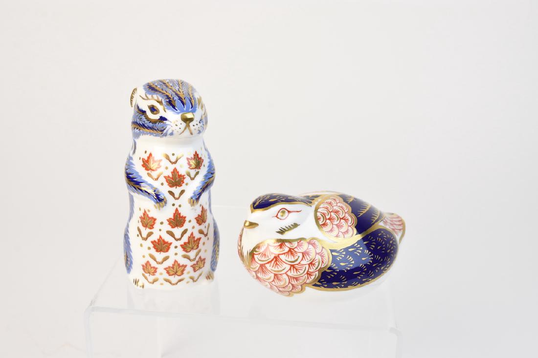 (2) Royal Crown Derby English Bone China Figurines: Two Royal Crown Derby English bone China figurine paperweights, a red breasted bird with gold toned RCD button, 4" long and standing squirrel with leaves on chest and silver RCD button, 4" H. Both are