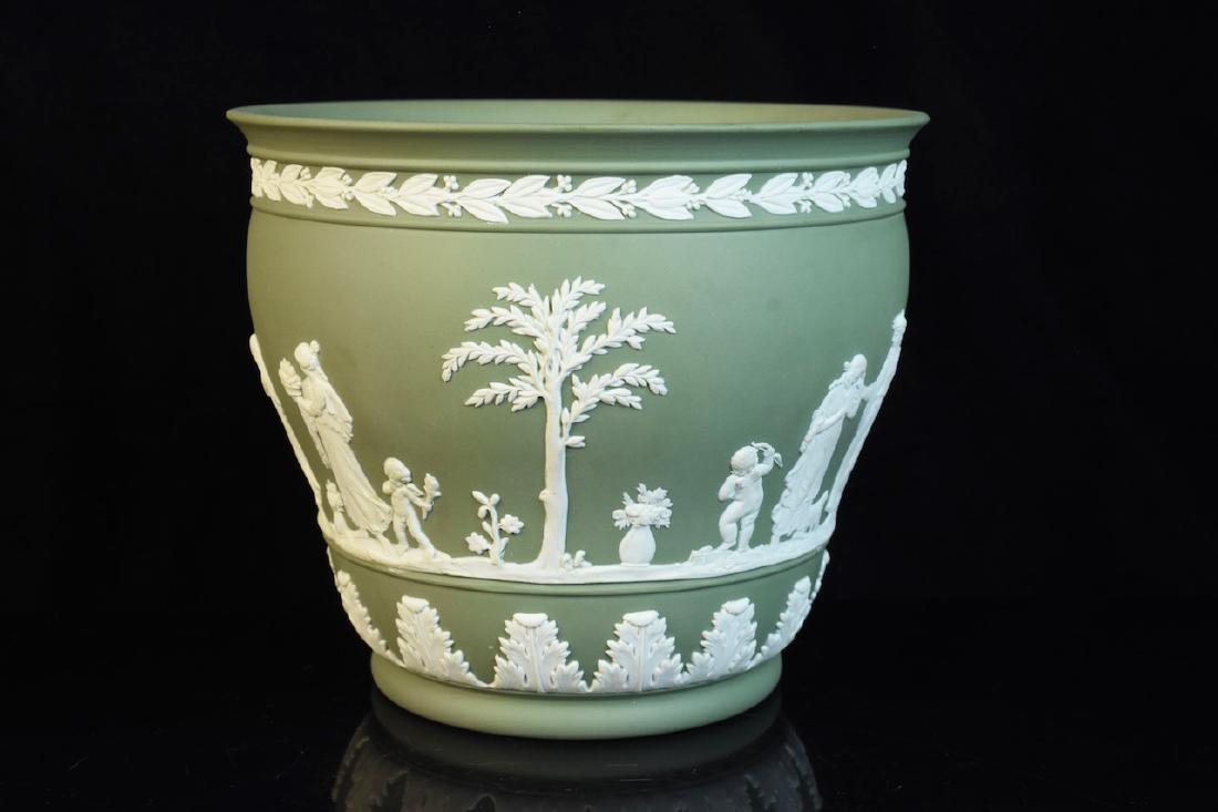 Wedgwood Cream on Green Jardinaire: Wedgwood Jasperware jardiniere in cream on green. It is dated 1956 and marked Wedgwood on the bottom. It is also in very good condition and measures 6" x 7" in diameter. Contact our recommended 3rd pa