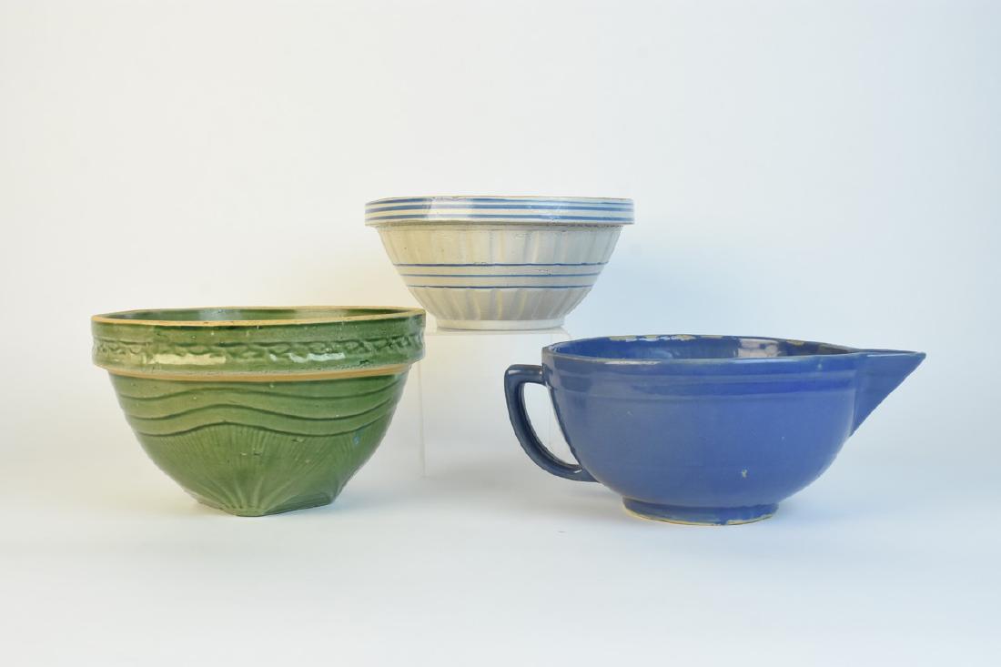 Vintage Stoneware & Batter Bowls: Vintage green mixing bowl with decorative pine branch pattern on rim, 9 1/2" diameter with 5 3/4" deep. Blue glazed battery bowl with spout, 9" diameter, mold imperfection on rim. Stoneware blue bande