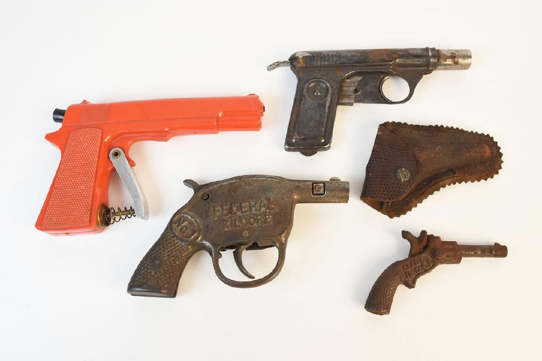 Vintage Toy cap Gun & Water Pistols: No. 1 Federal Kilgore cast iron cap gun, No. 71 tin water piston, a 75 Special repeating water pistol and a pocket size cap gun marked Cowboy on one side and Made in USA on the other. It comes in a sm