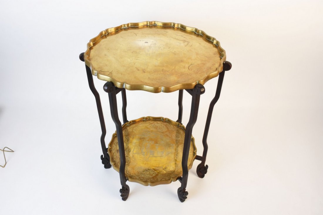 Chinese Engraved 2-Tier Brass Charger Folding Table: Chinese two tier charger folding table. There are two brass chargers, each with intricate Chinese engraved scenes and uniquely scalloped rims made in China. Large tray has a 16 1/2" diameter, the smal