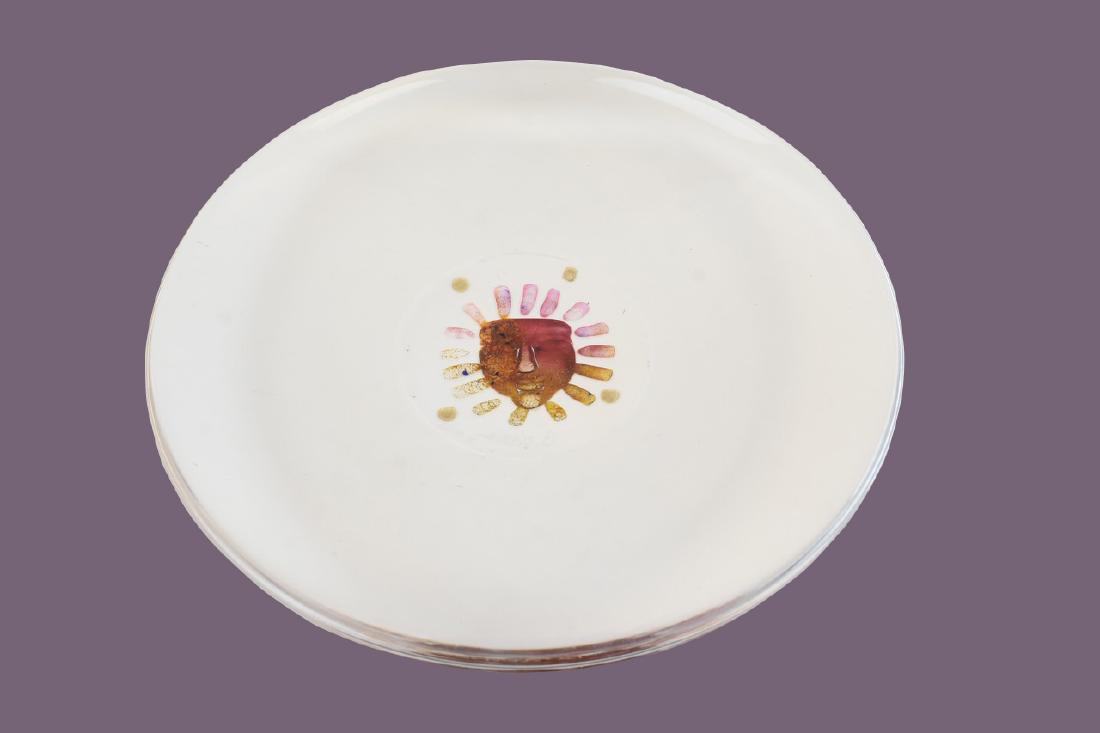 Kosta Boda Signed B. Vallien Art Glass Plate: Kosta Boda clear art glass plate with a sun face as the focal point. It is signed and dated 9-14-93 by the artist and numbered 79,281. This fun piece is in solid condition with minor surface scratches