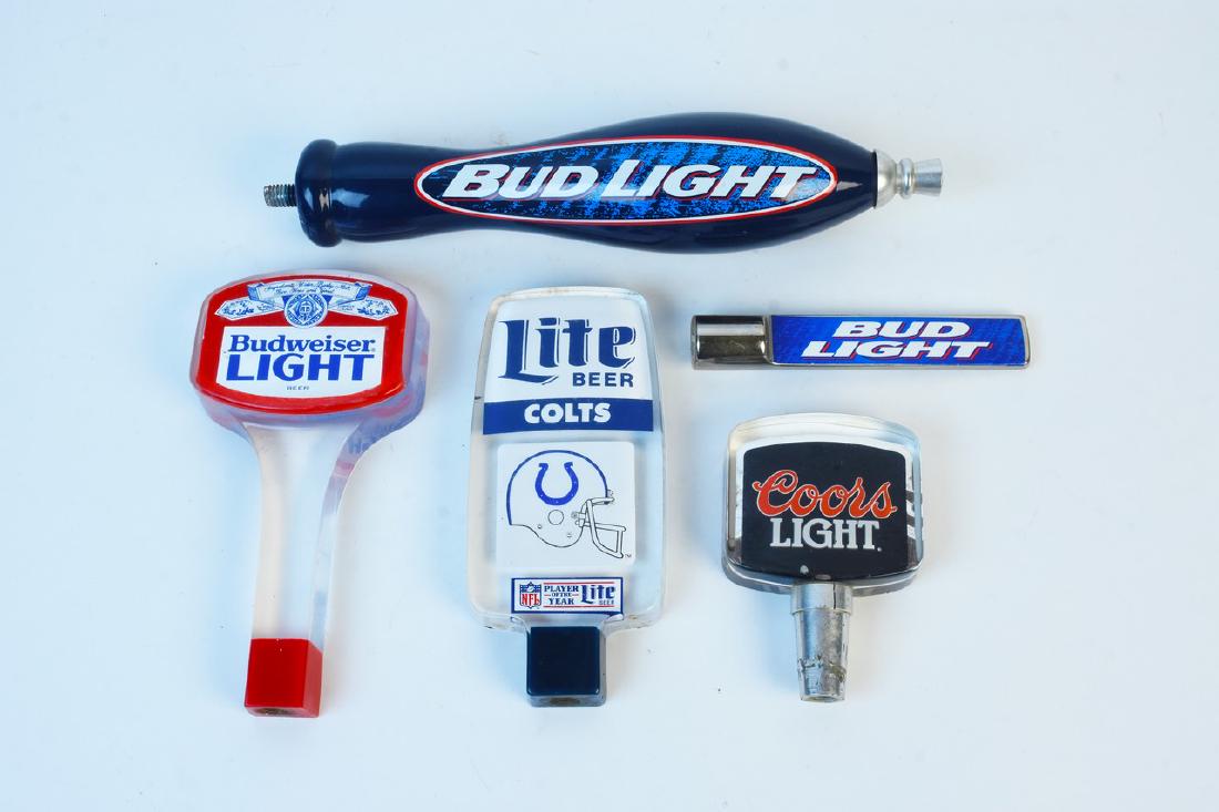 Miller Lite, Bud Light, Coors Light Beer Taps: A collection of American brand beer taps. The lot includes five beer taps including a Colts acrylic beer tap. The largest measures 10" long. Light surface scratches and markings. Contact our recommend