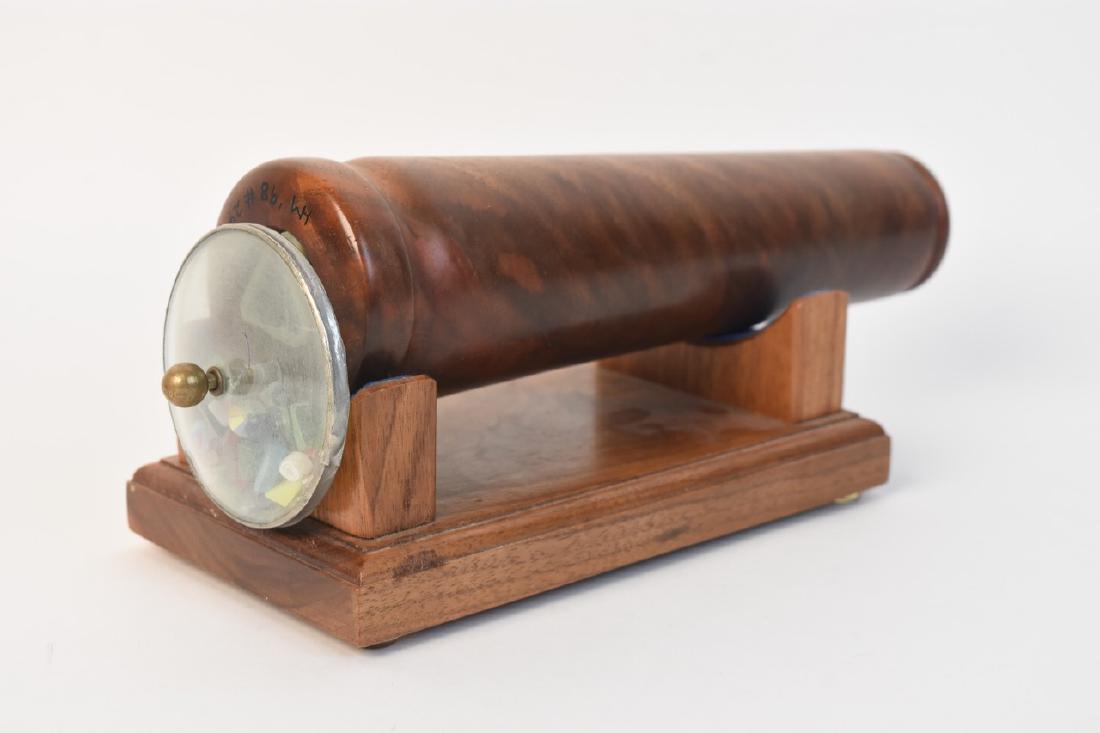 Wood Kaleidoscope; signed: Wood cone shaped kaleidoscope with wood base signed HM '98 #24. This 8 3/4" kaleidoscope is in good condition and works great to reflect bright colors and fun patterns. Contact our recommended 3rd par