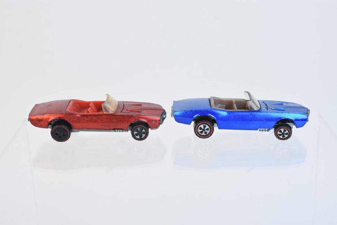 1968 Redline Hot Wheels Firebirds: A pair of Hot Wheels redline series 1968 Custom Firebirds. The pair includes a blue car with clear windows and a light gray interior; and a Hong Kong variation with red paint job and red interior. The