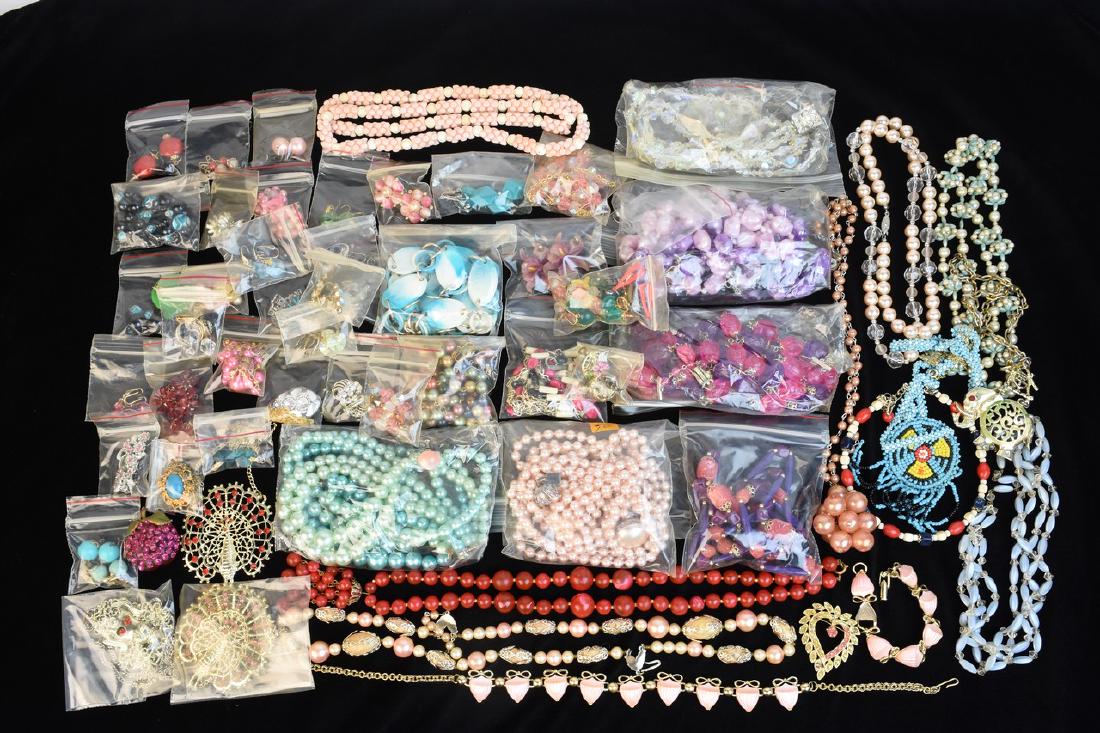 Assorted Costume Jewelry: An assortment of vintage costume jewelry including necklaces, brooches, clip-on earrings, and more. Included is a Royal brand necklace with doves and a heart; silver tone floral Monet clip-on earrings