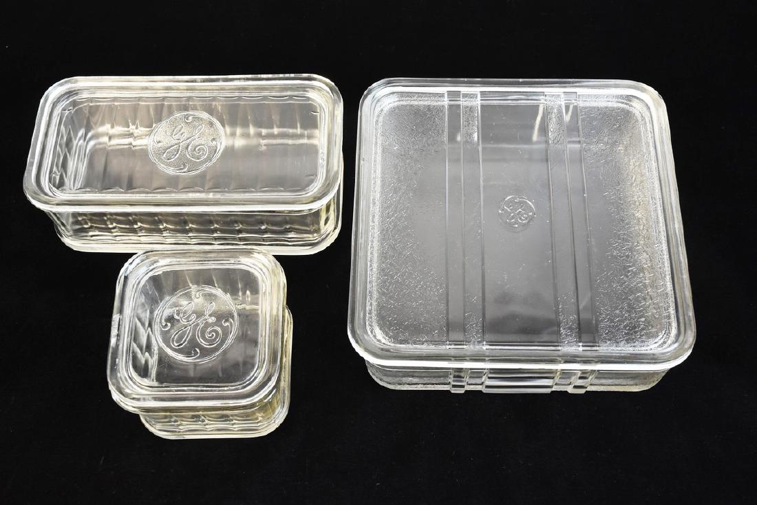 (3) General Electric Glass Refrigerator Dishes: (3) General Electric glass lidded refrigerator containers. All are GE logo embossed. These are nice heavy, durable containers. Largest measures 8 1/2" x 8 1/2", chips. Medium sized container measures