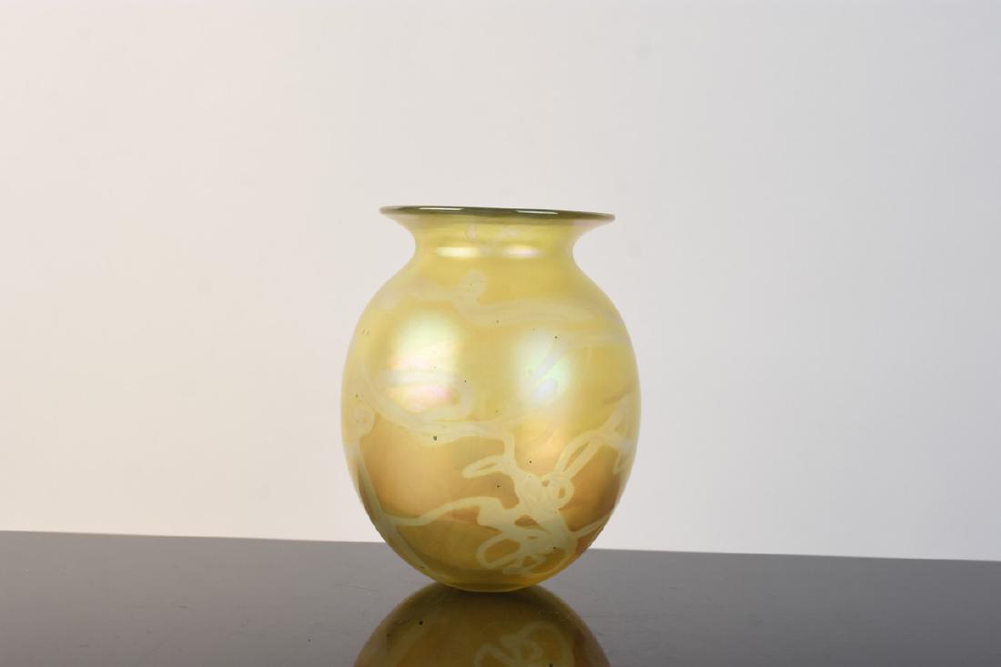 Robert Eickholt Iridescent Art Glass Vase: A Robert Eickholt art glass vase. This vase is yellow in color with silver tone iridescent free-form lines scrolling throughout. It measures approximately 5.95" H. There are areas of discoloration, cl