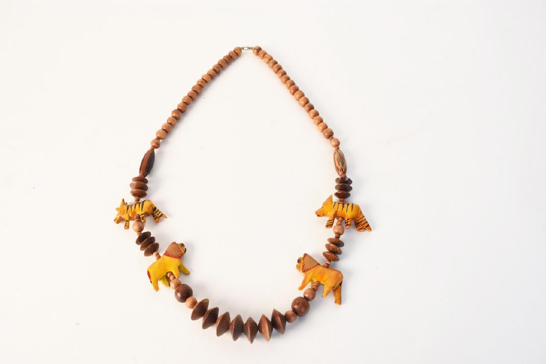 Lion & Tiger Wooden Beaded Necklace: A necklace comprised of wooden beads includes two painted lions & tigers. It includes a silver tone turn clasp and is unmarked. Light surface scratches and loss of paint. Contact our recommended 3rd p