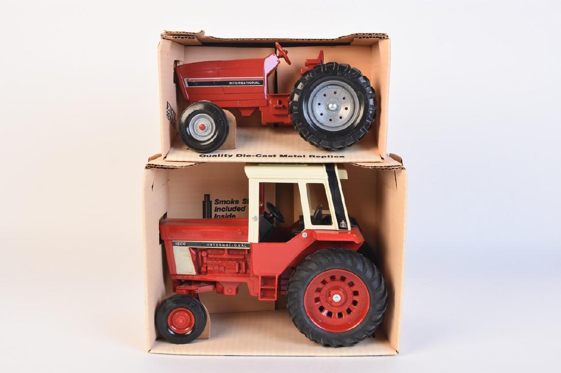 Ertl Diecast International Tractors: A pair of Ertl diecast International tractors in original packaging. The pair of 1:16 scale replicas include a #463 International 1586 Tractor with Cab; and a #415 International Row Crop Tractor. Orig