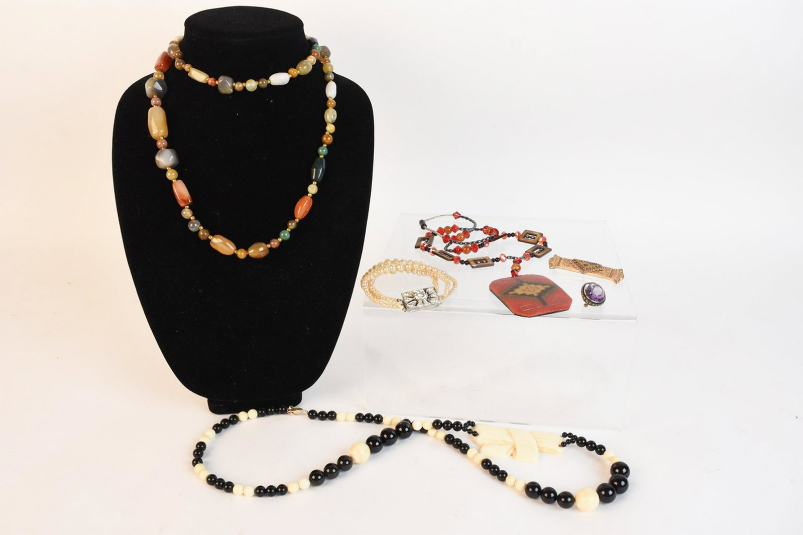Vtg. Beaded Necklaces & Other Costume Jewelry: An assortment of costume jewelry including three unique beaded necklaces, one with a large Bakelite ribbon shaped charm. Also included is a clear purple gemstone presented in an 830 silver setting, ma