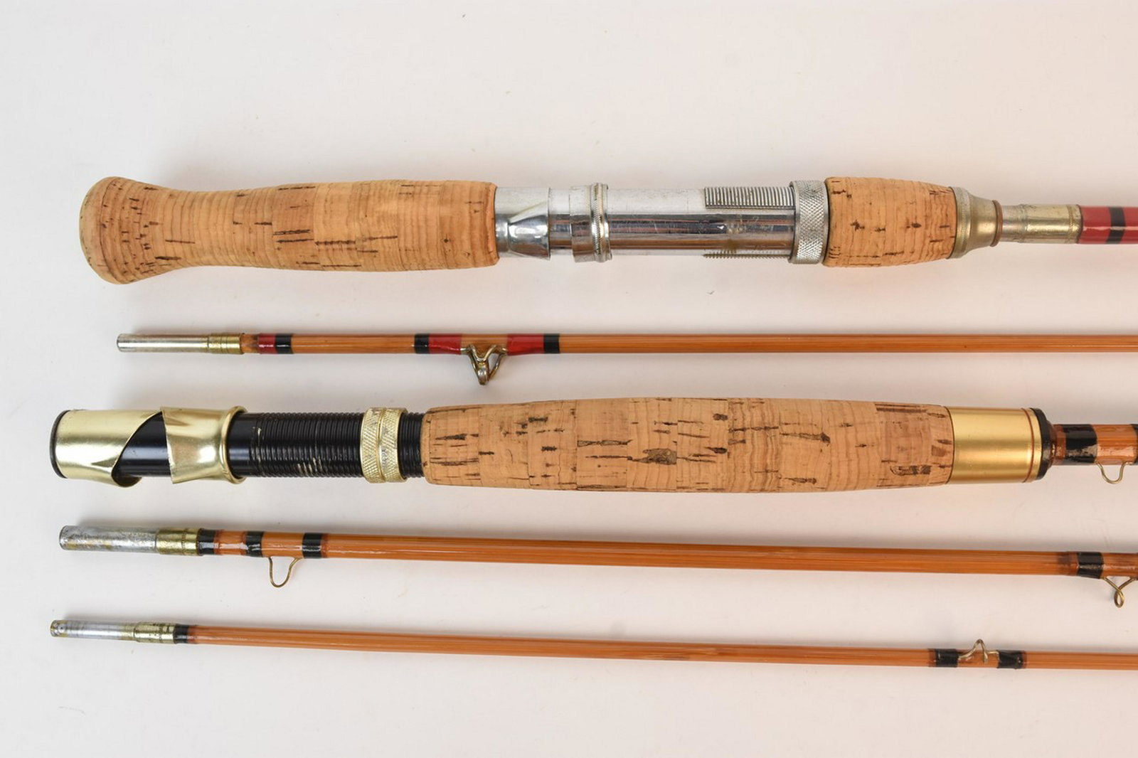 South Bend Bait Company Bamboo Fly Rods: A pair of South Bend Bait Company vintage collapsible split bamboo fly fishing casting rods including one 4' marked "35-4' near its handle. Rods are 4' and 9' with cork handles. Moderate wear- surface
