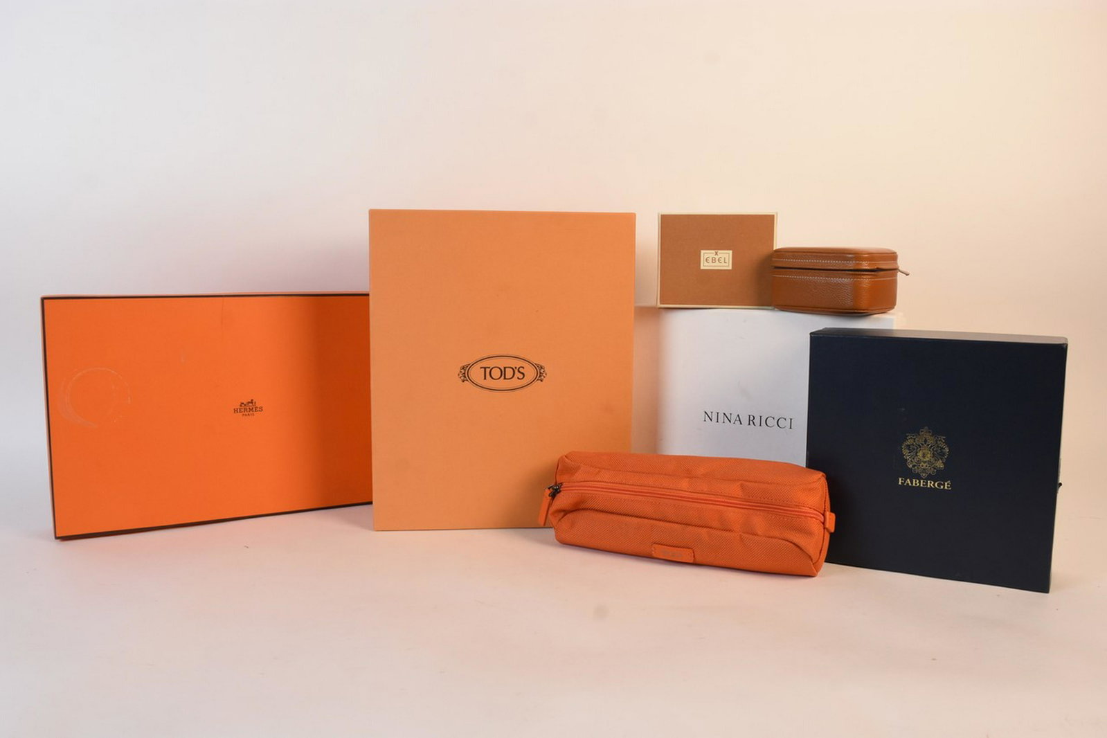 Designer Box Lot Incl. Hermes: An assortment of designer boxes with lids including Hermes, Tod's, Fabergé, Ninaricci, and Ebel. Also included is a Tumi nylon toiletrie bag with a zipper closure. Hermes box measures 3" H x 15" W x 