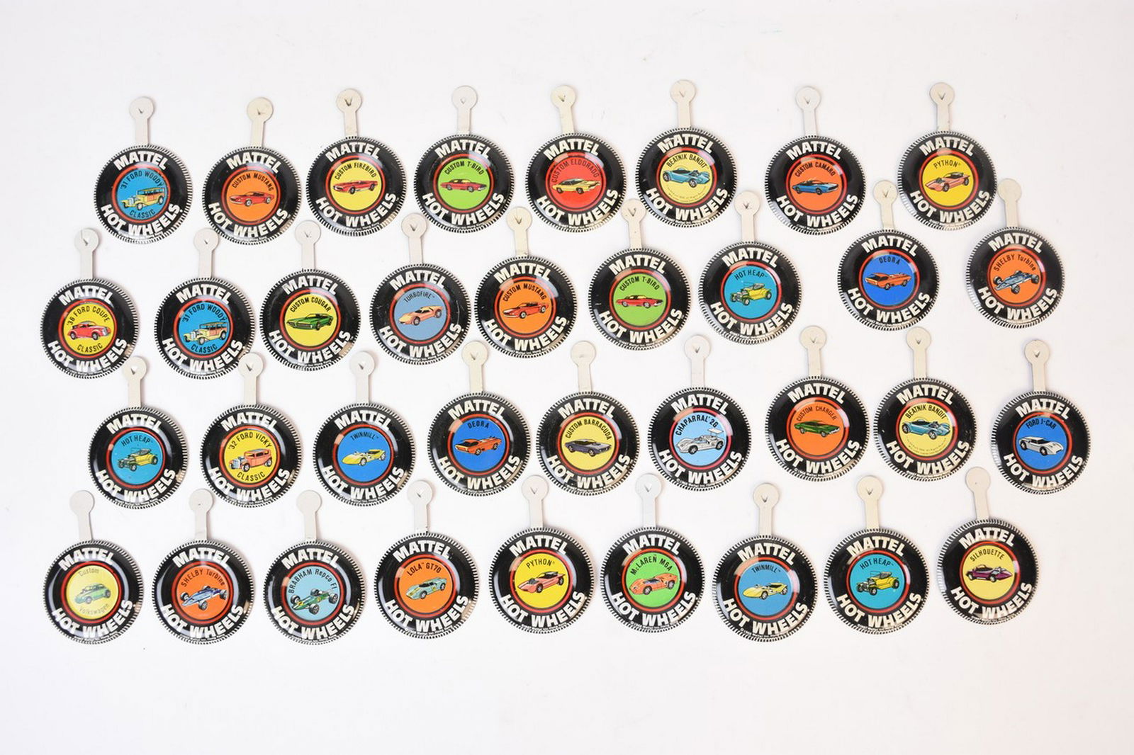 Redline Metal Button Badges: A selection of thirty-six Mattel Redline Hot Wheels button badges. Includes Python, Deora, Twinmill, Custom Cougar, Custom T-Bird, and more. Overall good condition, light surface markings, stains, and