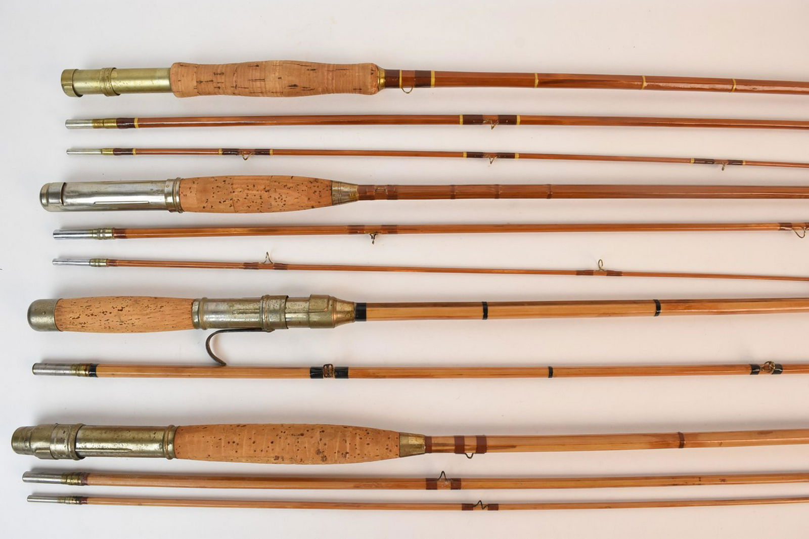 (4) Vintage Bamboo and Split Cane Fly Rods: An assortment of four collapsible vintage fly fishing casting rods comprised of bamboo and split cane. Include cork handles. Light to moderate wear; discoloration; chips to handles. Contact our recomm
