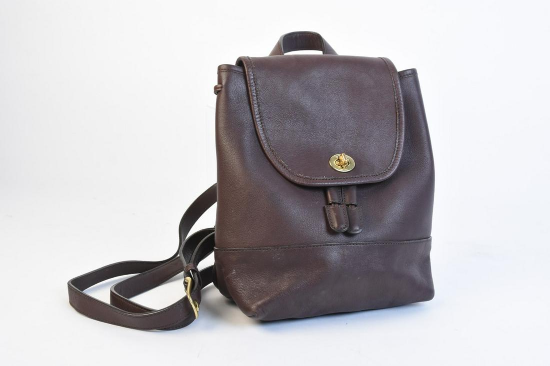 Vintage Coach Brown Leather Mini Backpack: brown backpack A vintage Coach leather mini backpack in brown. It features two adjustable back straps and a top handle with a flap and turn-lock closure. The bag features a drawstring top with an inte