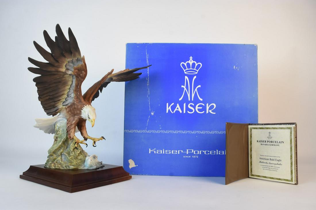 Kaiser LE American Bald Eagle Figurine: A limited edition bisque porcelain figurine depicting an American Eagle by German company Kaiser. The bald eagle rests on a wood stand and includes a certificate of authenticity numbered "753/2000." A