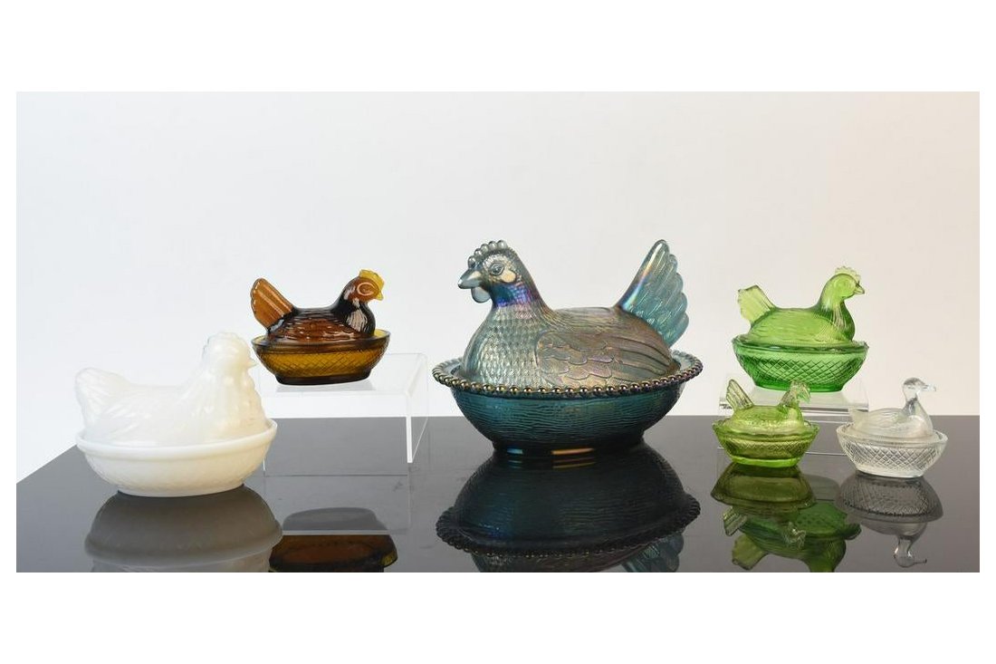 Glass Hen on Nest Dishes: An assortment of six glass nesting hen and duck dishes in various sizes. Includes milk glass, carnival glass, amber glass, clear pressed glass, and green glass. Light surface markings. No discernible