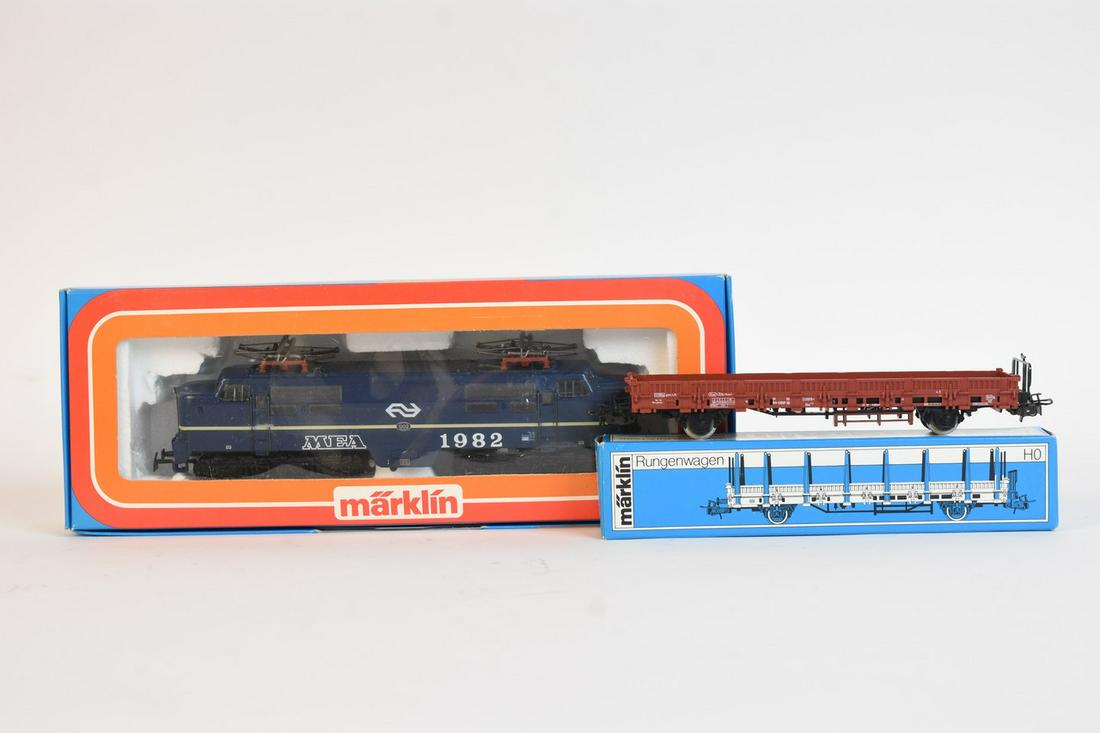 Märklin HO Loco & Freight Car: A pair of HO scale Märklin railroad train cars. Includes #3161 MEA Electric Locomotive; and #4694 Stake Car. In original packaging with light shelf wear. Largest box measures approx. 4" H x 10.5" W x