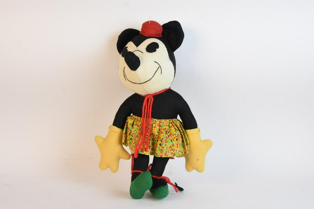 1940s Wool Felt Minnie Mouse Doll: A handmade wool felt doll depicting Disney's Minnie Mouse with pie-eyes and pointed nose. Wearing floral skirt, lace bloomers, yellow gloves, green shoes, red pillbox hat, and red yarn scarf. Some loo